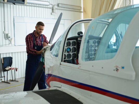 Man repairing the propeller of a plane