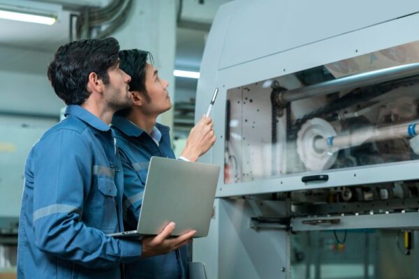 Two engineers looking at cnc machinery